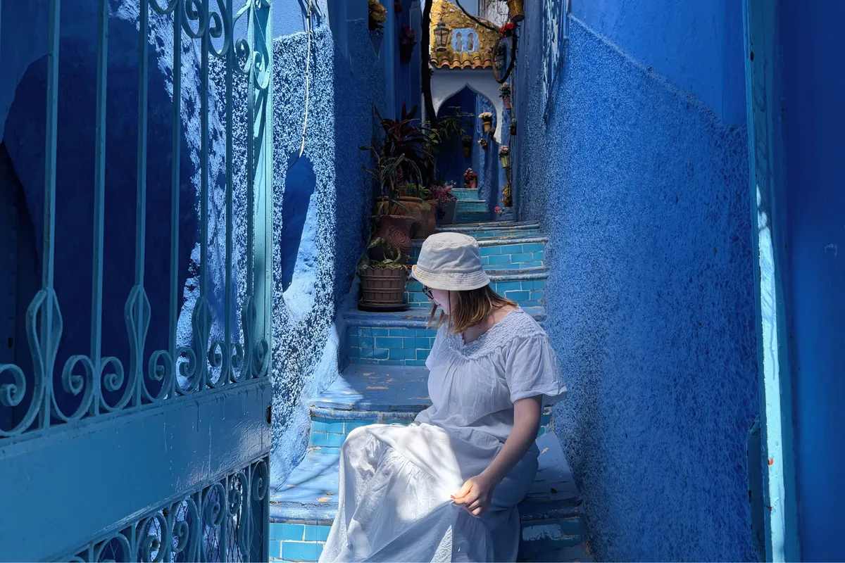 Chica sentada en un rincón bonito en Chefchaouen