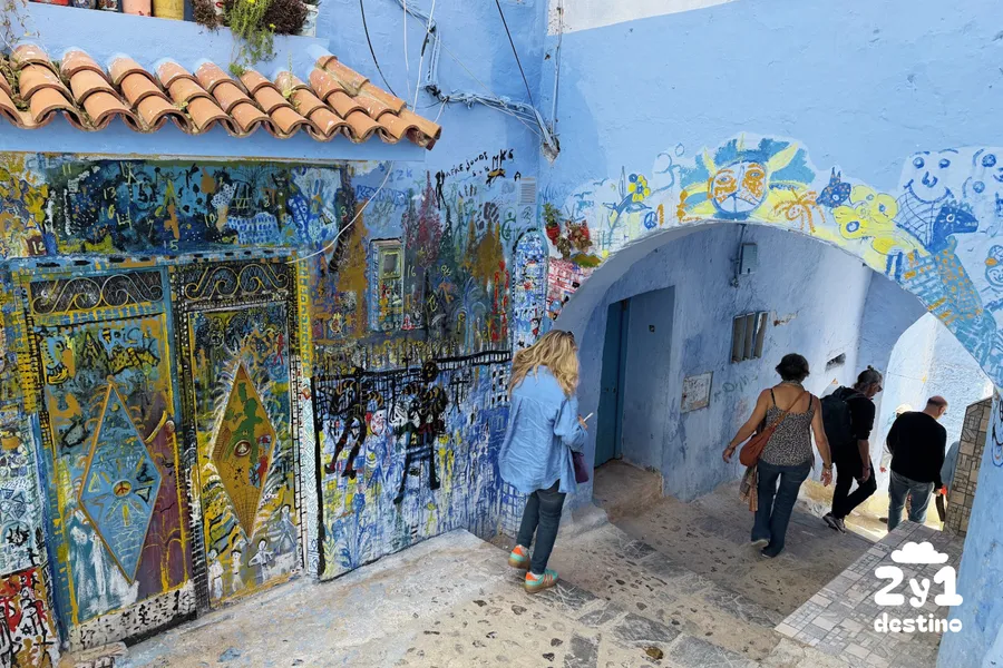Callejón azul con escaleras y macetas, con personas, rincón bonito de Chefchaouen