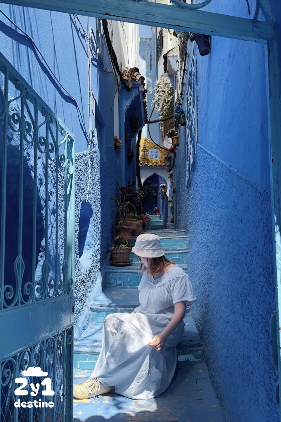 Callejón azul con escaleras y macetas y chica, uno de los rincones más fotogénicos de Chefchaouen
